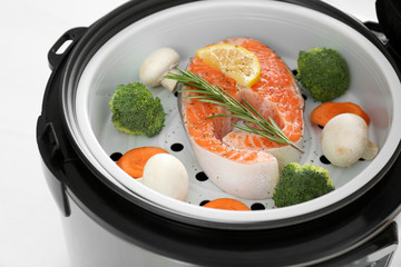 Salmon steak with garnish in multi cooker, closeup