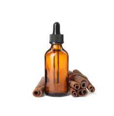 Bottle of essential oil and cinnamon sticks on white background