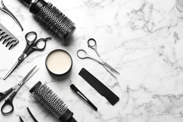 Flat lay composition with scissors and other hairdresser's accessories on white marble background....