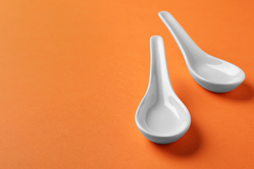 Miso soup spoons on orange background. Space for text