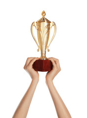 Young woman holding gold trophy cup on white background, closeup