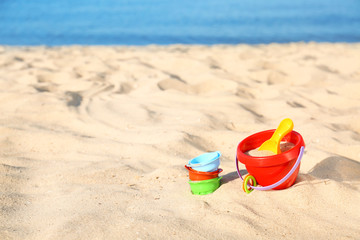 Fototapeta na wymiar Set of plastic beach toys on sand near sea. Space for text