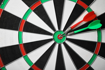 Red and green arrows on dart board, top view