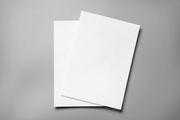 Blank paper sheets for brochure on grey background, top view. Mock up - obrazy, fototapety, plakaty