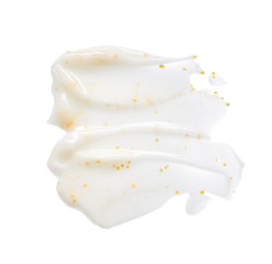 Smears and texture of white face cream with yellow peas on a white background