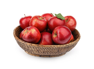 Fototapeta na wymiar Wicker bowl of ripe juicy red apples with leaf on white background