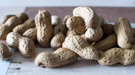 Salted and roasted peanuts sit on the peanuts still in their dry shell before being peeled and ground into delicious vegan peanut butter