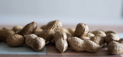 Salted and roasted peanuts sit on the peanuts still in their dry shell before being peeled and ground into delicious vegan peanut butter