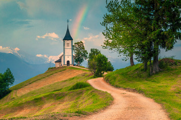 Idyllic rainbow landscape with Saint Primoz church, near Jamnik, Slovenia
