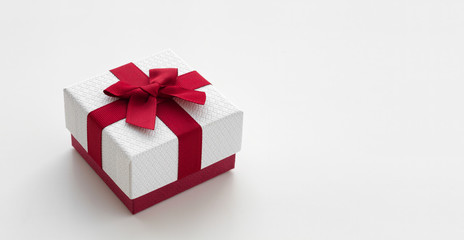 White gift box with red ribbon isolated on white background. 