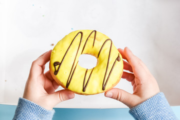 Child's hand reaching to grab doughnut