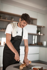 Obraz premium close up. man slicing bread for sandwiches