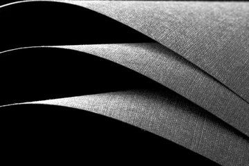 Black curved sheets of paper, strong contrast of light and shadow