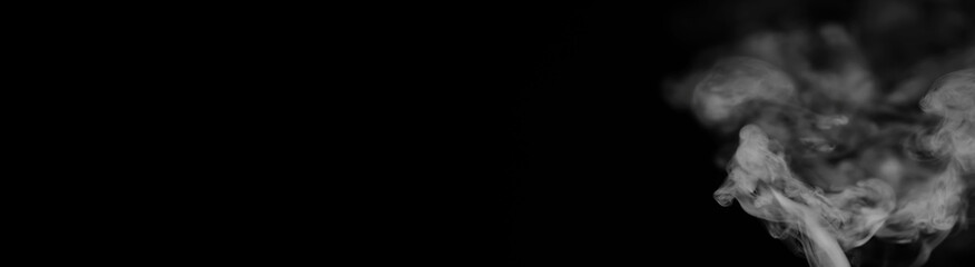 White smoke on a black background. Texture of smoke. Clubs of white smoke on a dark background for an overlay