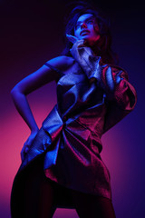 Women style. Fashion model in stylish dress in neon lights