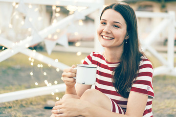 girl laughs at a festive cozy celebration, bokeh garlands in the background