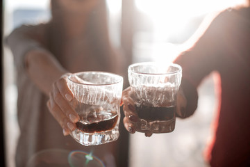close up. glasses of juice in the hands of a young couple