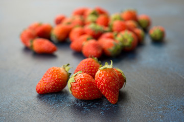 Fresh red strawberries on a blue concrete background.