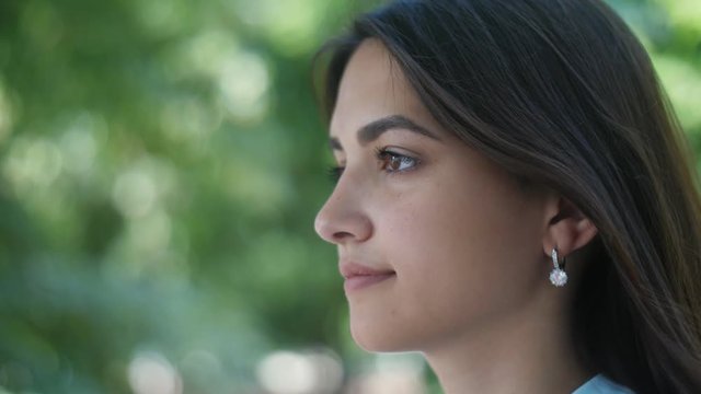 Gorgeous girl standing and thinking about her he-man in park in summer in slo-mo