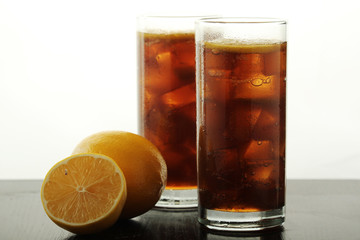 Glasses with cuba libre cocktail or cola with ice or cold tea with lemon