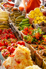 Various pickles and marinated vegetables on the market. Sauerkraut, pickled cucumbers, eggplants, tomatoes, apples