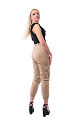 Back view of young sexy blonde woman tossing hair turning and looking at camera. Full body isolated on white background. 