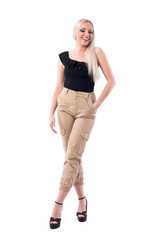 Fototapeta premium Stunning blonde glamorous woman laughing and looking down wearing cream color pants. Full body isolated on white background. 