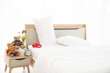 The modern or minimal interior bedroom design decorated with comfortable  double bed, white bedding such as blanklet, pillows and wooden furniture