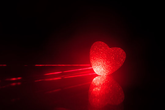 Blurred neon heart icon on a dark background. Copy space with red bright  colorful heart on black background Stock Photo | Adobe Stock