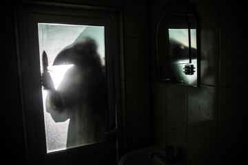Horror silhouette of woman in window. Scary halloween concept Blurred silhouette of witch in...
