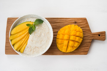 Oatmeal bowl with fresh mango. Healthy breakfast.