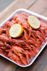 A lot of  bright red boiled  crawfish with lemon