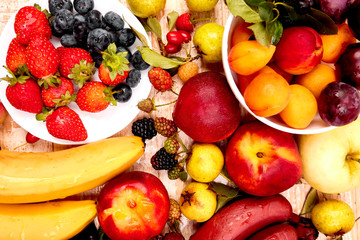 Flat lay of fruits over white wooden background, top view. Vegetarian, vegan, dieting, clean eating, weight loss ingredients.  Summer fruit food background. Copy space.