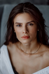 Fototapeta premium Portrait of a beautiful brunette girl on a dark background
