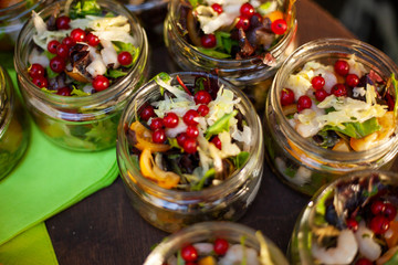 Salad in glass jars. Salad of vegetables and fruits for the holiday table. Food on the street. Food shot in natural light. Light helpful treats for guests.