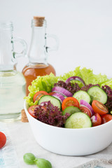 Summer vegetable salad with seasonal vegetables on rustic wooden background.