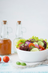 Summer vegetable salad with seasonal vegetables on rustic wooden background.