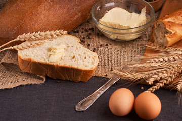 Different bread and wheat on the rustic table. Selective focus, close up