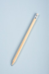 A pencil on the blue paper background with copy space