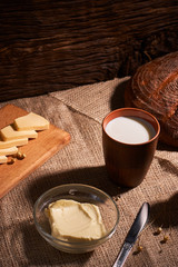 Butter and chees and milk for breakfast, over rustic wooden background with copy space. Morning breakfast