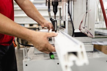 Manual worker assembling PVC doors and windows. Manufacturing jobs. Selective focus. Factory for aluminum and PVC windows and doors production.