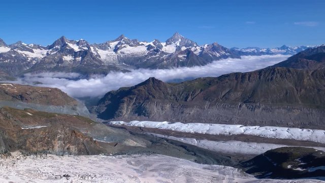 Aerial low shot over Schwarzgletscher glacier, camera tilting up to reveal mountain range in background, Zermatt area, Switzerland