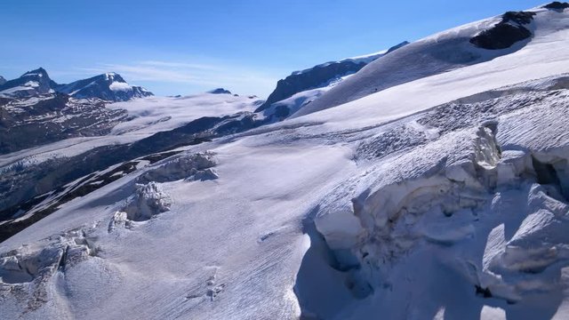 Aerial low forward shot over glacier crevasses and seracs in Zermatt area, Switzerland