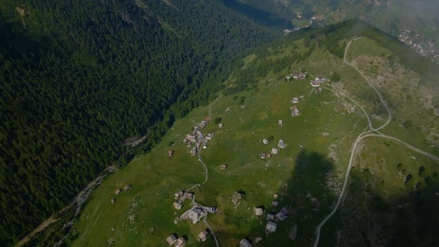 High aerial shot over Findeln hamlet near Zermatt, Switzerland. Patches of fog flying around