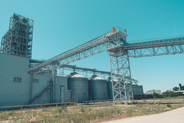 Fototapeta na wymiar Svetlovodsk, Ukraine – 27 May, 2018: Modern Agricultural Silos against blue sky. Storage and drying of grains, wheat, corn, soy, sunflower. Agricultural silo at feed mill factory
