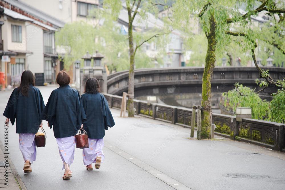 Wall mural japanese woman family wearing kimono and walking at kinosaki onsen village street in toyooka city, h