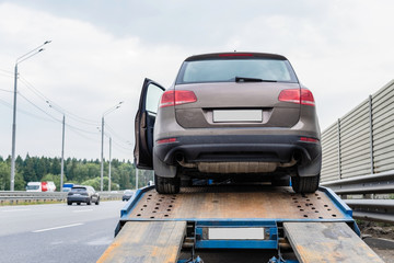  Tow truck towing a broken down car on the highway