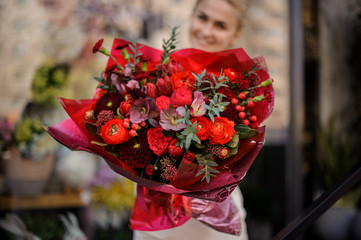 Girl stands with a completely red bouquet