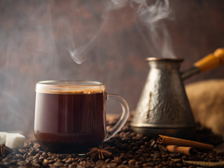 Espresso transparent glass Cup and coffee beans on the table .