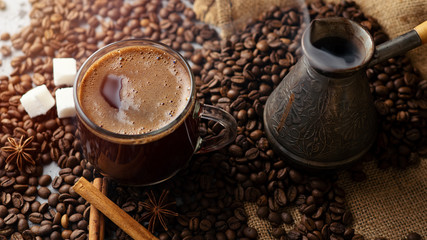 Espresso transparent glass Cup and coffee beans on the table .